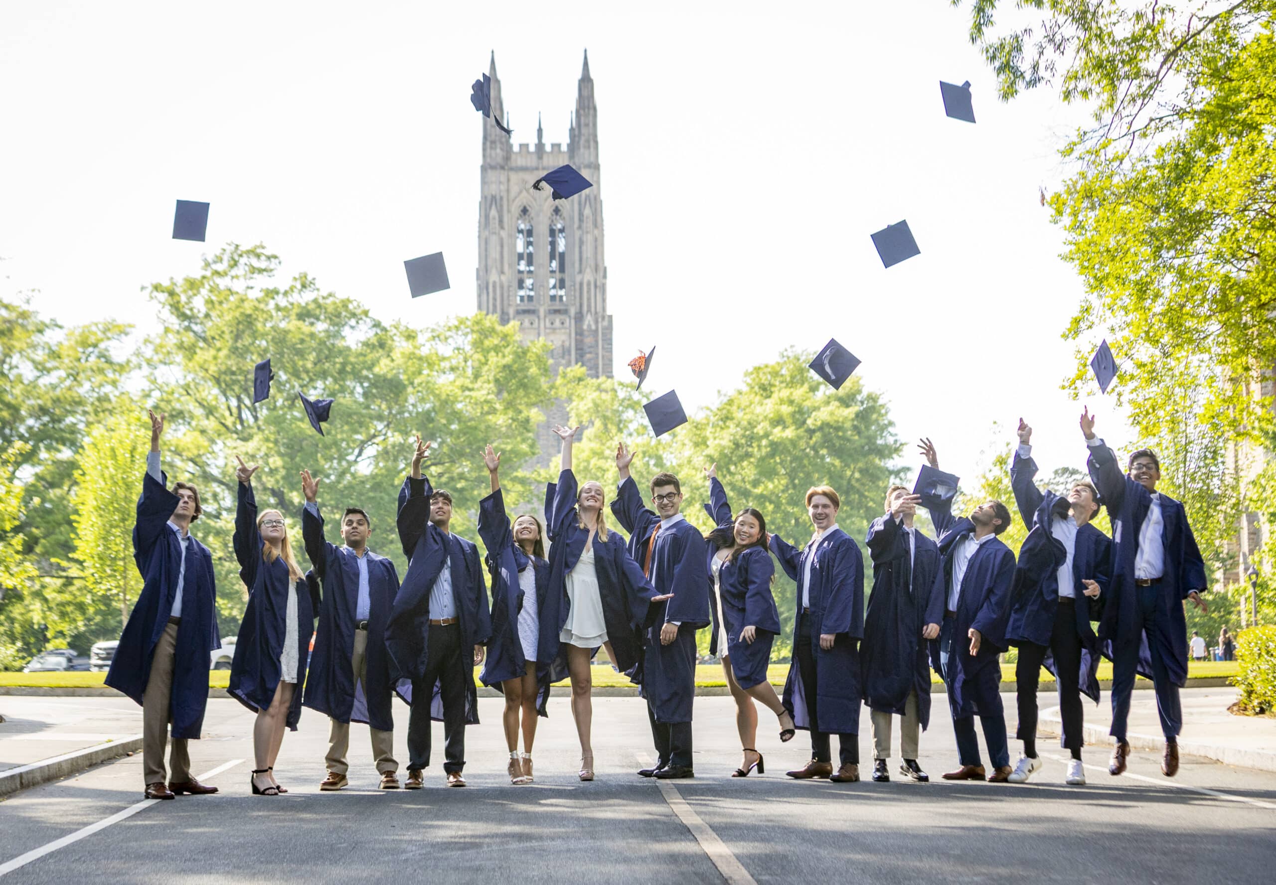 Trinity College of Arts & Sciences and Pratt School of Engineering students toss their caps during a graduation photo session on Chapel Drive.