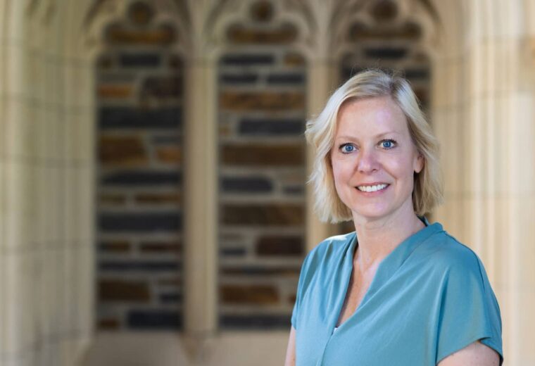 Christy Bozic poses in a blue blouse outside of Duke Chapel.
